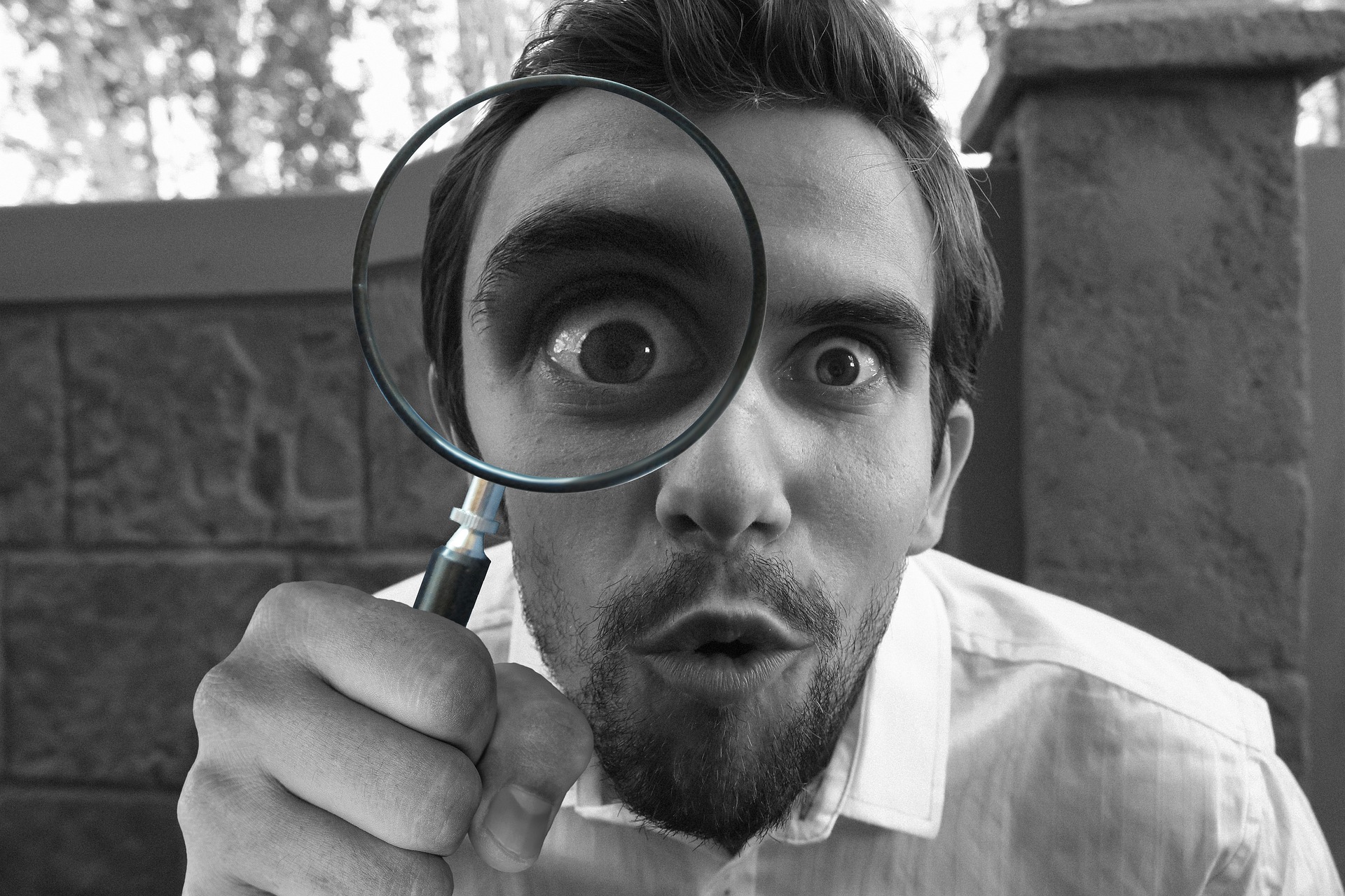 man with magnifying glass to his eye